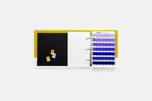 Load image into Gallery viewer, A white ring binder page is open on a light grey background. The left page has a black insert with three small colourful sticky notes, and the right page shows a white divider with multiple blue and purple Pantone colours.